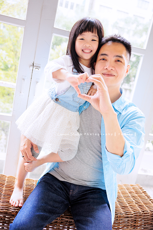 Ida媽麻一家第三次來拍照，四歲半和一歲半的姊弟倆，笑容與童趣洋溢，爸拔媽麻也陪著一起玩得很開心，這張是爸拔抱著姊姊兩人各一隻手做出愛心的形狀的父女倆的互動合照！