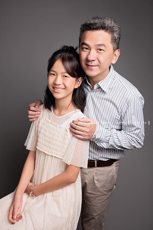 Coco媽麻一家第二次來拍照，依舊優雅美麗的Coco媽麻，女兒也悄悄長成漂亮的青少女，這張是爸拔和女兒的合照，女兒坐著、爸拔從後面抱著她，兩人看著鏡頭微笑，也是好幸福的一張父女的合照！