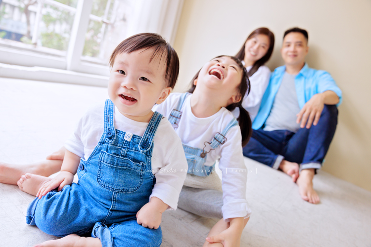 Ida媽麻一家第三次來拍照，四歲半和一歲半的姊弟倆，笑容與童趣洋溢，爸拔媽麻也陪著一起玩得很開心，這張是姊姊和弟弟坐在爸拔媽麻前方，姊姊笑得超開心、弟弟看著鏡頭微笑的可愛互動照！