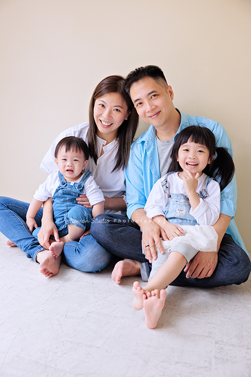 Ida媽麻一家第三次來拍照，四歲半和一歲半的姊弟倆，笑容與童趣洋溢，爸拔媽麻也陪著一起玩得很開心，這張是爸拔抱著姊姊、媽麻抱著弟弟，一家人坐在地上很開心地笑著的全家福寫真照！
