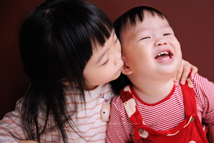 Ida媽麻一家第三次來拍照，四歲半和一歲半的姊弟倆，笑容與童趣洋溢，爸拔媽麻也陪著一起玩得很開心，這張是姊姊正抱著弟弟要親弟弟的姊弟倆的互動紀錄照！