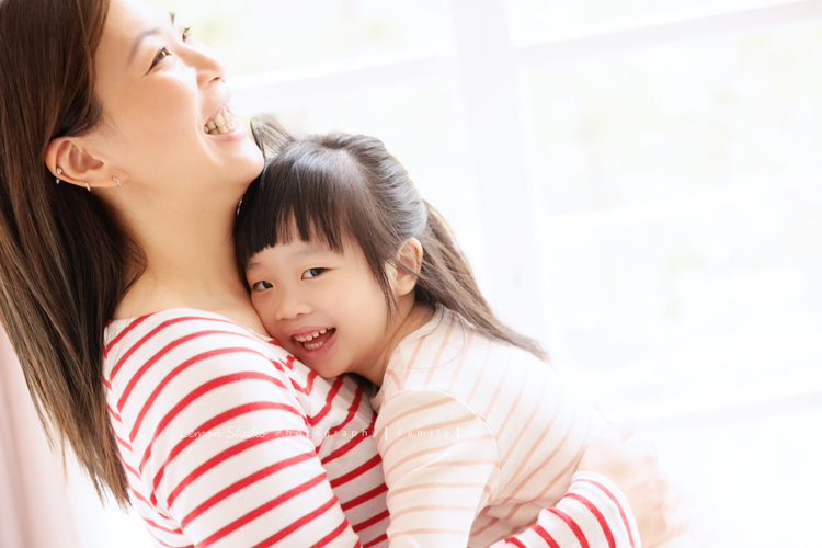 Ida媽麻一家第三次來拍照，四歲半和一歲半的姊弟倆，笑容與童趣洋溢，爸拔媽麻也陪著一起玩得很開心，這張是媽麻抱著姊姊，姊姊看著鏡頭開心地笑著的母女兩人的互動紀錄照！