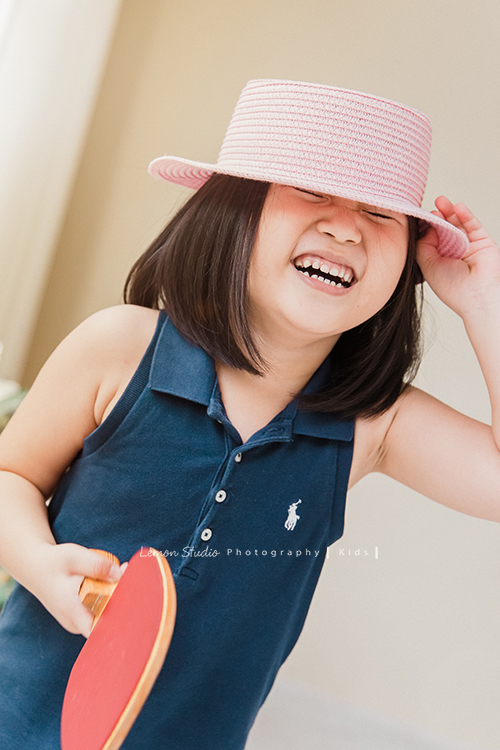 誠＆蓉一家第二次來拍照，兄妹倆的感情依舊很好，有好多可愛的互動瞬間被記錄下來，這張是妹妹蓉拿著桌球拍沒有看鏡頭，戴著帽子笑得很俏皮的一張兒童寫真！
