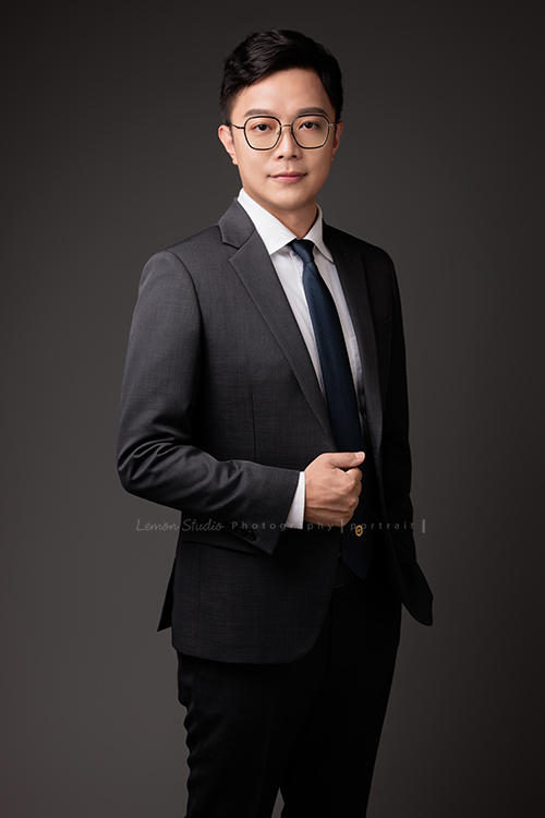 圓璽不動產專屬顧問團隊，以最真誠與專業的樣貌入鏡，每一位都展現出獨一無二的形象與風格，這是顧問Tim一手放在口袋、一手抓著西裝外套、沈穩地看著鏡頭、很專業的一張不動產顧問形象照！