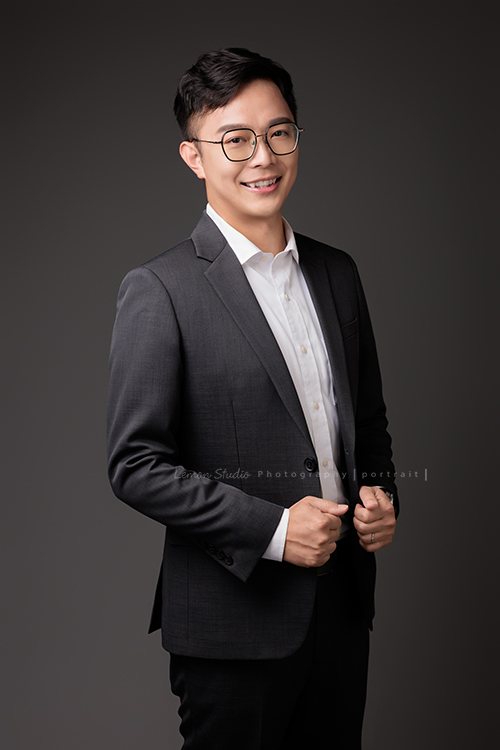 圓璽不動產專屬顧問團隊，以最真誠與專業的樣貌入鏡，每一位都展現出獨一無二的形象與風格，這是顧問Tim兩手抓著西裝外套看著鏡頭微笑、很專業的一張不動產顧問形象照！