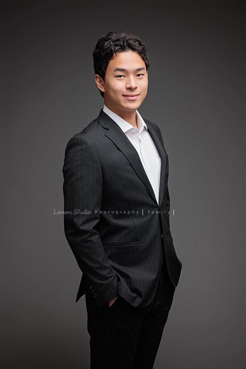 Cindy 媽麻一家來拍照，在美國念書的兒子瑋，帥氣又溫暖，一家人換上正式與休閒的服裝，每一張照片都記錄下最自然的互動與情感，這張是兒子瑋穿著西裝、兩手放在口袋，微笑地看著鏡頭，是一張很帥氣的個人寫真！