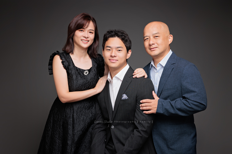 Cindy 媽麻一家來拍照，在美國念書的兒子瑋，帥氣又溫暖，一家人換上正式與休閒的服裝，每一張照片都記錄下最自然的互動與情感，這張是兒子瑋穿著西裝、爸爸和媽媽站在他的兩邊，一家三口很有質感及自然的全家福寫真！