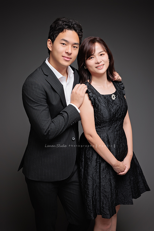 Cindy 媽麻一家來拍照，在美國念書的兒子瑋，帥氣又溫暖，一家人換上正式與休閒的服裝，每一張照片都記錄下最自然的互動與情感，這張是兒子瑋穿著西裝、搭著媽媽的肩膀，母子兩人的合照相片！