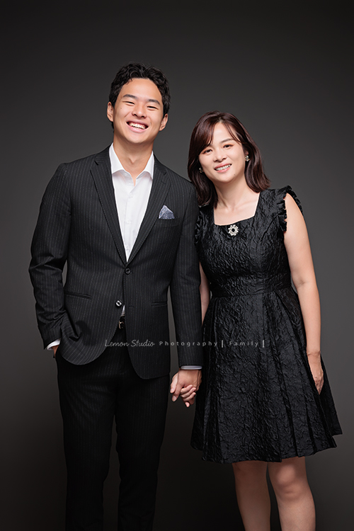 Cindy 媽麻一家來拍照，在美國念書的兒子瑋，帥氣又溫暖，一家人換上正式與休閒的服裝，每一張照片都記錄下最自然的互動與情感，這張是兒子瑋穿著西裝、和媽媽手牽手兩人笑得很開心的母子兩人的合照相片！
