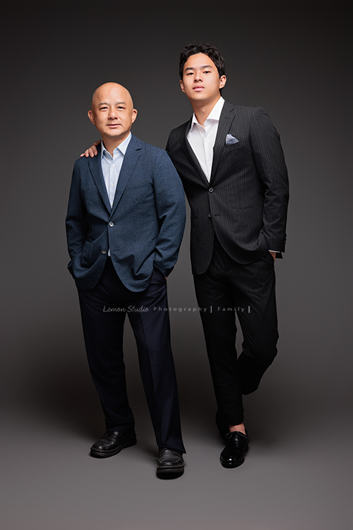 Cindy 媽麻一家來拍照，在美國念書的兒子瑋，帥氣又溫暖，一家人換上正式與休閒的服裝，每一張照片都記錄下最自然的互動與情感，這張是兒子瑋穿著西裝、一手放口袋、一手搭著爸爸的肩膀，父子兩人帥氣的合照相片！