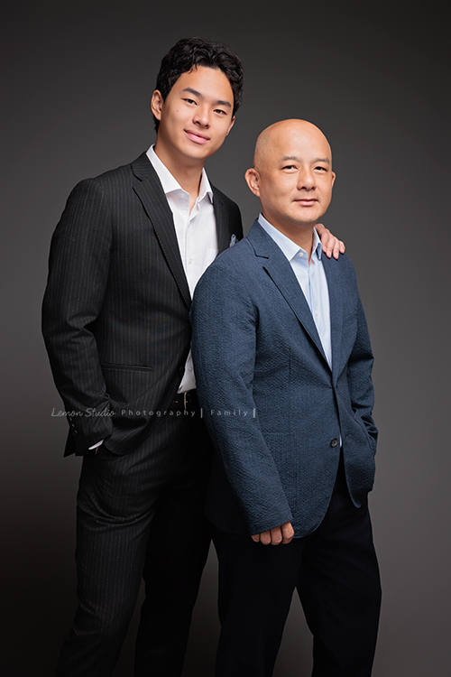 Cindy 媽麻一家來拍照，在美國念書的兒子瑋，帥氣又溫暖，一家人換上正式與休閒的服裝，每一張照片都記錄下最自然的互動與情感，這張是兒子瑋穿著西裝、一手放口袋、一手搭著爸爸的肩膀，父子兩人的合照相片！