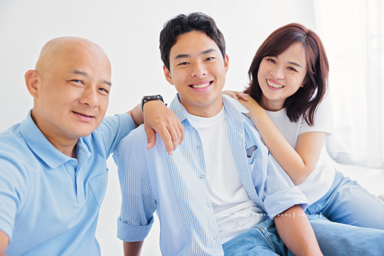 Cindy 媽麻一家來拍照，在美國念書的兒子瑋，帥氣又溫暖，一家人換上正式與休閒的服裝，每一張照片都記錄下最自然的互動與情感，這張是一家人穿藍色系的衣服，兒子瑋和爸爸媽媽看著鏡頭笑得很開心，一家三口很有質感及自然的全家福寫真！