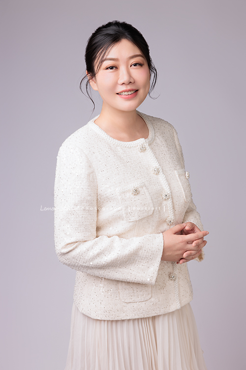 音樂治療師婷婷來拍照,拍完一套正式服裝的形象照後,她換上白色洋裝,輕輕抱著吉他入鏡,這張是音樂治療師婷婷穿著正式的一套白色服裝,兩手交叉在身體前方、看著鏡頭笑得很美的一張形象照!