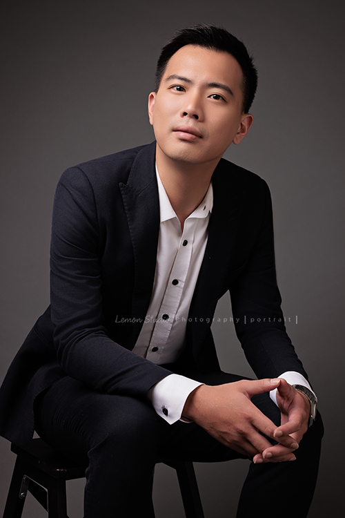 圓璽不動產專屬顧問團隊，以最真誠與專業的樣貌入鏡，每一位都展現出獨一無二的形象與風格，這是顧問承安坐在椅子上雙手互握，看著鏡頭的一張很有意境的不動產顧問形象照！