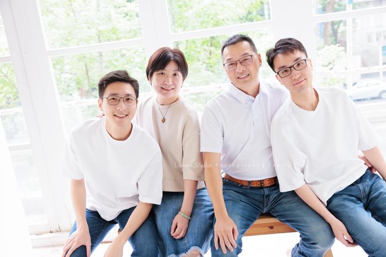 大學畢業是人生旅程的重要里程碑，Kathy媽麻一家選擇用鏡頭，留下一家人最珍貴的陪伴，每一張相片裡，都裝滿了對孩子的愛與祝福，這張是一家四口穿著白色上衣與牛仔褲＆裙坐在窗邊的全家福！