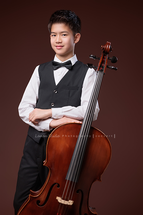 暟與大提琴，一同走進鏡頭，隨著光影與姿態變化，每一個角度，都映出暟不同的氣息與神韻，這張是暟站著雙手交疊在大提琴上、看著鏡頭的一張很帥氣的音樂寫真照！