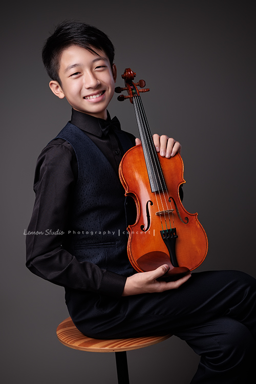 Alston為了音樂會演出，帶著小提琴來拍照，換上襯衫與西裝背心後，整個人一下子成熟了許多，沉穩又帶點小紳士的氣質，這張是Alston坐著兩手拿著提琴、笑得很燦爛地看著鏡頭的音樂寫真！
