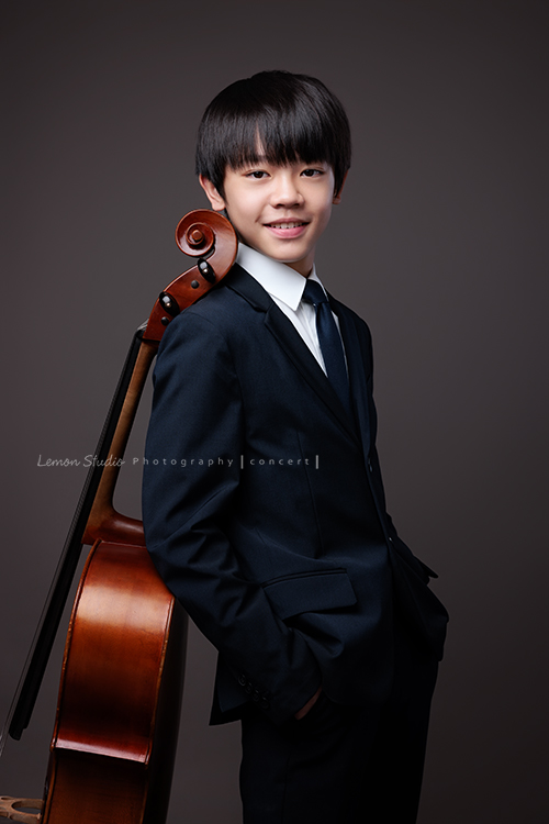 Jimmy帶著大提琴走進棚內,帥氣的笑容搭配大提琴的優雅氣質,格外迷人,拉琴時沉浸在音樂裡的神情,充滿專注與熱愛,所有的努力,都是為了迎接即將到來的音樂會,這張是Jimmy站著背靠著大提琴、兩手放口袋、帥氣地看著鏡頭微笑的大提琴音樂寫真!