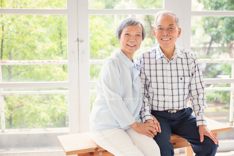 璧瑩和兄弟姊妹帶著伯父伯母一起來拍照，三代同堂的畫面好熱鬧也好溫暖，爺爺奶奶看著兒女與子孫，那份滿足與喜悅，靜靜寫在微笑裡，這張是伯父伯母兩人的夫婦寫真，伯父伯母一起坐在窗邊，兩人手牽著手拍照，牽手一輩子，兩人的合照拍起來很溫暖及美麗！