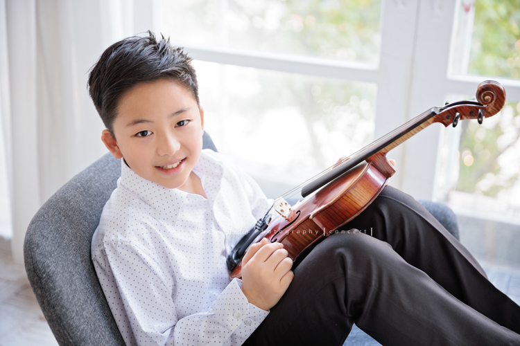 瑞帶著中提琴來拍音樂會寫真，和同學們一起為即將到來的演出努力準備著，穿上白襯衫的瑞，在鏡頭前顯得特別帥氣、沉穩，這張是瑞將中提琴放在他的腿上，坐在椅子上，看著鏡頭微笑的一張帥氣的音樂會寫真照！