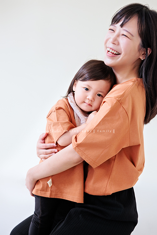 米粒媽麻一家帶著爺爺奶奶與姑姑一起來拍照，這天捕捉到許多可愛又自然的家庭瞬間，爺爺奶奶活潑又疼愛孫子，身為健身教練的姑姑，也和家人留下了不少有趣又充滿活力的合照，這張是媽麻抱著女兒的兩人互動紀錄！