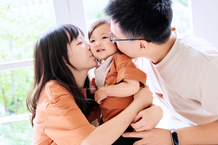 米粒媽麻一家帶著爺爺奶奶與姑姑一起來拍照，這天捕捉到許多可愛又自然的家庭瞬間，爺爺奶奶活潑又疼愛孫子，身為健身教練的姑姑，也和家人留下了不少有趣又充滿活力的合照，這張是爸拔媽麻親親女兒臉頰的三人互動紀錄！