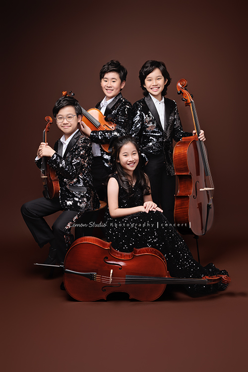 Tristan & Natalie兄妹倆帶著大提琴來拍照，和同學們一起為音樂會做準備，兄妹倆活潑又有默契，這次大家準備的團服也格外亮眼，每一張照片都展現出屬於他們自己的風格與魅力，這張是Tristan & Natalie和另外兩位團員的四人的音樂會寫真團照！