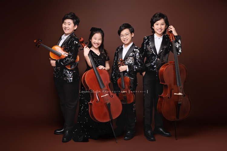 Tristan & Natalie兄妹倆帶著大提琴來拍照，和同學們一起為音樂會做準備，兄妹倆活潑又有默契，這次大家準備的團服也格外亮眼，每一張照片都展現出屬於他們自己的風格與魅力，這張是Tristan & Natalie和另外兩位團員，四人都站著拿著自己的樂器的四人的音樂會寫真團照！