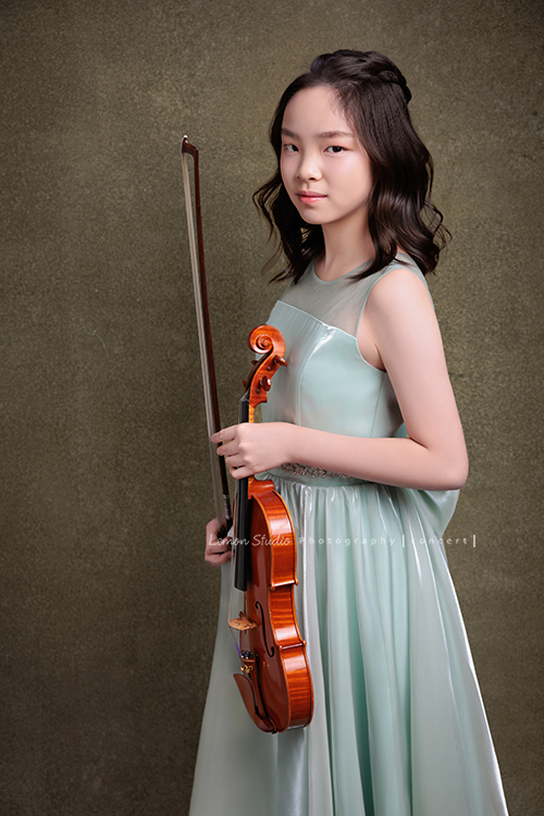 這是 Audrey 第三次來拍音樂會寫真,今年的她,又長大了一些,越來越美,也越來越有屬於自己的氣質,這張是Audrey穿著淡綠色的小禮服,一手拿著小提琴、一手拿著弓側身並看著鏡頭微笑的一張很美的小提琴音樂會寫真!