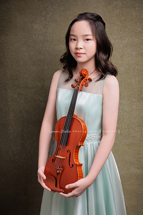 這是 Audrey 第三次來拍音樂會寫真,今年的她,又長大了一些,越來越美,也越來越有屬於自己的氣質,這張是Audrey穿著淡綠色的小禮服,兩手拿著小提琴在身體前方、看著鏡頭微笑的一張小提琴音樂會寫真!