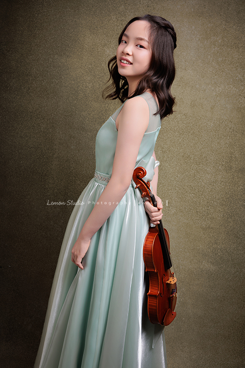 這是 Audrey 第三次來拍音樂會寫真,今年的她,又長大了一些,越來越美,也越來越有屬於自己的氣質,這張是Audrey穿著淡綠色的小禮服,一手拿著小提琴在身後,側身並轉過頭來看著鏡頭微笑的一張很美的小提琴音樂會寫真!