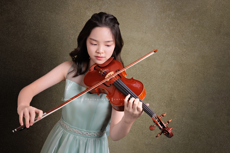 這是 Audrey 第三次來拍音樂會寫真,今年的她,又長大了一些,越來越美,也越來越有屬於自己的氣質,這張是Audrey穿著淡綠色的小禮服,正專注地拉小提琴的一張音樂會寫真!