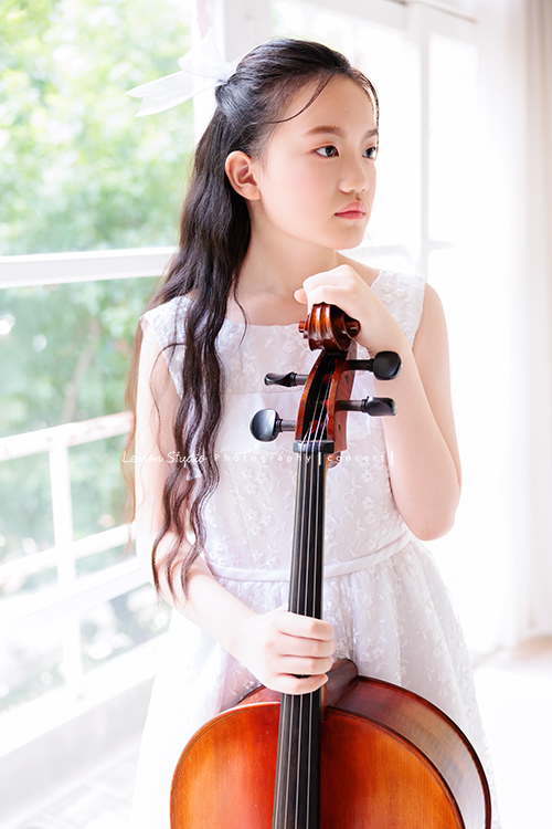 Candice帶著她的大提琴來拍攝音樂寫真,白色的小禮服在光線中顯得輕柔,深棕色的大提琴靜靜陪在身旁,多了一份沉穩,也多了一份優雅,這張是Candice雙手扶著大提琴沒有看鏡頭很有意境的音樂寫真照!