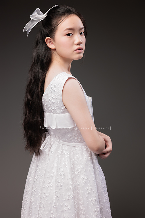 Candice帶著她的大提琴來拍攝音樂寫真,白色的小禮服在光線中顯得輕柔,深棕色的大提琴靜靜陪在身旁,多了一份沉穩,也多了一份優雅,這張是Candice雙手拿著樂譜側身轉過頭來酷酷地看著鏡頭的音樂寫真照!