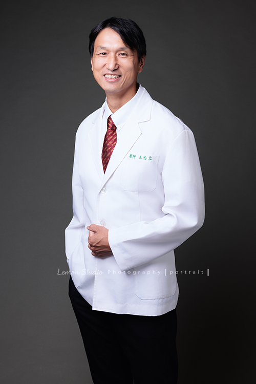 中醫師王醫師來拍醫師形象照,這張是王醫師一手放口袋、一手放在醫師袍上,看著鏡頭微笑的專業中醫師形象照!