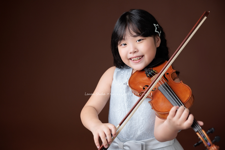 Jonathan & Chloe兄妹倆來拍提琴音樂寫真，再次站在鏡頭前，今年的 Jonathan 明顯長大了許多，Chloe非常活潑可愛，主動幫忙帶動現場氣氛，讓整個拍攝過程溫馨又美好，這張是Chloe正要拉提琴、看著鏡頭微笑的很甜美的一張音樂寫真照！
