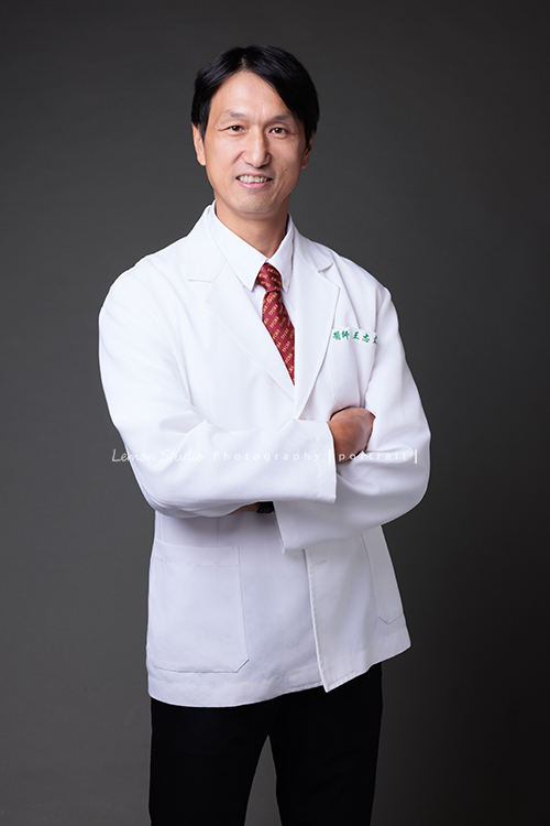 中醫師王醫師來拍醫師形象照,這張是王醫師兩手抱在身體前方,看著鏡頭微笑的專業中醫師形象照!