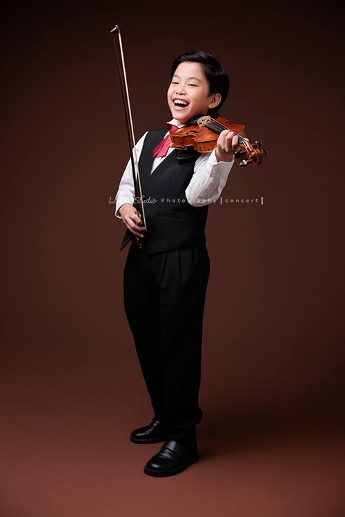 Jonathan & Chloe兄妹倆來拍提琴音樂寫真，再次站在鏡頭前，今年的 Jonathan 明顯長大了許多，Chloe非常活潑可愛，主動幫忙帶動現場氣氛，讓整個拍攝過程溫馨又美好，這張是Jonathan拿著提琴、沒有看鏡頭笑得很開心的音樂寫真照！