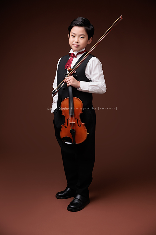Jonathan & Chloe兄妹倆來拍提琴音樂寫真，再次站在鏡頭前，今年的 Jonathan 明顯長大了許多，Chloe非常活潑可愛，主動幫忙帶動現場氣氛，讓整個拍攝過程溫馨又美好，這張是Jonathan一手拿提琴、一手放口袋，微笑並帥氣地看著鏡頭的音樂寫真照！