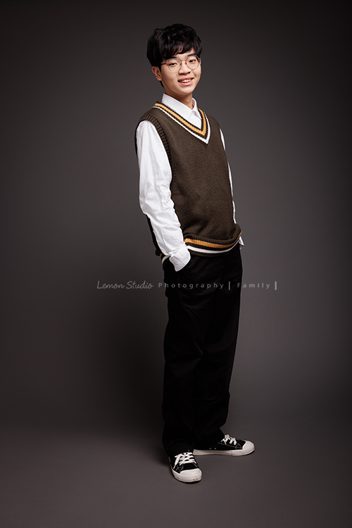 台怡媽麻和先生,帶著二十歲的兒子一起來家庭寫真,這次台怡媽麻特別準備了,三人不同顏色的帽T,這張是兒子穿著較正式的衣服站在背景前、雙手放在口袋內、看著鏡頭微笑的個人寫真照!