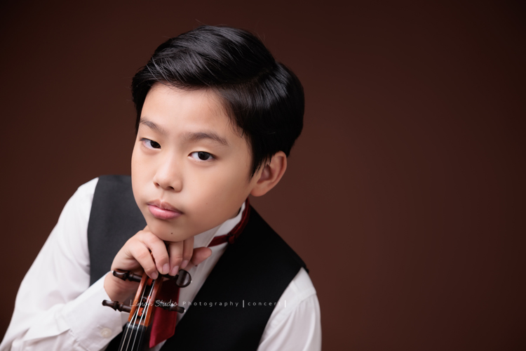 Jonathan & Chloe兄妹倆來拍提琴音樂寫真，再次站在鏡頭前，今年的 Jonathan 明顯長大了許多，Chloe非常活潑可愛，主動幫忙帶動現場氣氛，讓整個拍攝過程溫馨又美好，這張是Jonathan兩手拿著提琴、頭靠在手上、酷酷地看著鏡頭的音樂寫真照！