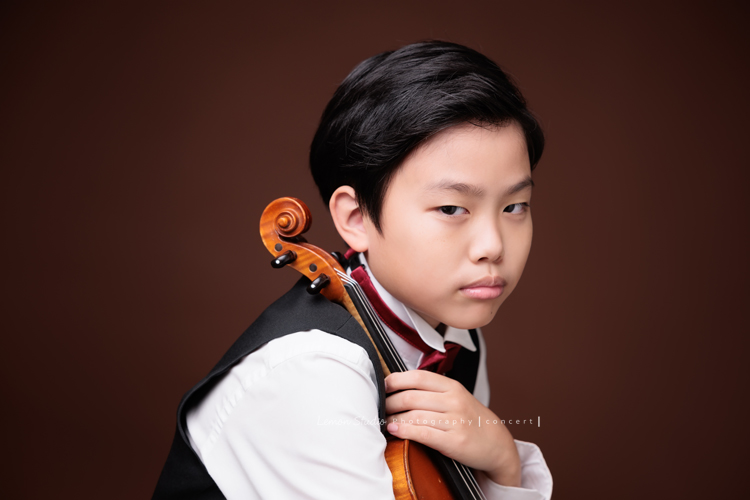 Jonathan & Chloe兄妹倆來拍提琴音樂寫真，再次站在鏡頭前，今年的 Jonathan 明顯長大了許多，Chloe非常活潑可愛，主動幫忙帶動現場氣氛，讓整個拍攝過程溫馨又美好，這張是Jonathan兩手拿著提琴、酷酷地看著鏡頭的音樂寫真照！