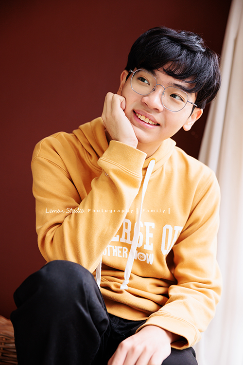 台怡媽麻和先生,帶著二十歲的兒子一起來家庭寫真,這次台怡媽麻特別準備了,三人不同顏色的帽T,這張是兒子穿著黃色的帽T、一手托著下巴,沒有看鏡頭但很輕鬆自在的個人寫真照!