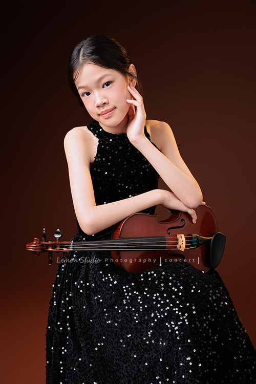 音樂班的 Isha要畢業了,這次拍攝準備了不同的禮服,每一張相片裡的Isha都好美,在音樂班的薰陶下,音樂好像早就成為她的日常,一個眼神、一個動作,都自然地帶著音樂的氣息,她要帶著這份從音符裡長出的自信,走向人生的下一個新階段,這張是 Isha穿著黑色小禮服坐在椅子上、一手扶著提琴、一手摸著臉頰,看著鏡頭的一張音樂班畢業音樂寫真紀念照!