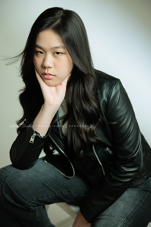 Audrey也是從小到大來拍過幾次照的孩子，隨著時間過去她也悄悄長大了啊，在高中這個階段，為她留下紀錄，這張是Audrey坐在椅子上一手托著下巴、一手放在大腿上、頭髮飄逸、很酷地看著鏡頭的很有時尚感的高中女孩寫真照！