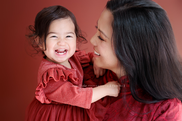 Kim媽麻一家第二次來到台灣，因為女兒Lilia真的很喜歡台灣，這個聖誕假期，他們又一起飛來過節，也因為在美國的左鄰右舍、朋友們一致推薦來檸檬巷館拍照，幾個月前Kim媽麻就先預約好了拍照行程，這張是Kim媽麻和小女兒Lenora互動的紀錄合照之一，媽麻看著可愛的Lenora，Lenora頭髮自然捲，這張的笑容好燦爛啊！