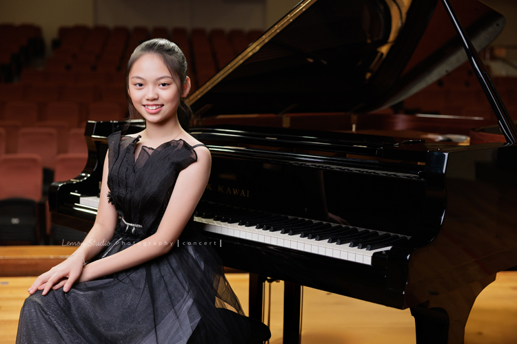 音樂班的Yuko即將畢業，帶著她的大提琴來到鏡頭前，在不同的禮服與不同的樂器之間，看見不一樣的她，這張是Yuko身穿一襲黑色禮服、坐在演奏廳的大鋼琴前、雙手交疊在大腿上、看著鏡頭笑容很美的一張很有氣質的音樂班畢業音樂寫真！