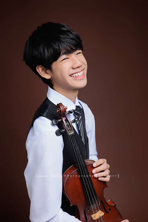 Timmy即將國中畢業，帶著他熟悉的提琴，站進鏡頭裡，黎爸捕捉了他不同的角度與情緒，這張是Timmy兩手拿著提琴在身旁、看著鏡頭笑容很燦爛的音樂寫真照！