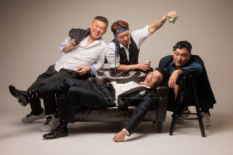 巧靈公司的團隊，每一年都會依尾牙的主題來拍團隊形象照，去年的主題很幽默，拍起來每一張都像電影劇照，大家在鏡頭前完全演技魂上身，這張是四位男同事，演出像是喝酒時的互動，一位已經醉倒在沙發、很像劇照的一張團體形象照！