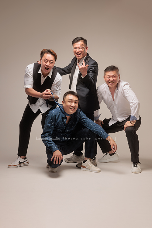 巧靈公司的團隊，每一年都會依尾牙的主題來拍團隊形象照，去年的主題很幽默，拍起來每一張都像電影劇照，大家在鏡頭前完全演技魂上身，這張是四位男同事，有人拉著另一位的領帶、有人比出有趣的手勢、四位都笑得很開心、是一張很有趣很幽默且很像劇照的一張團體形象照！